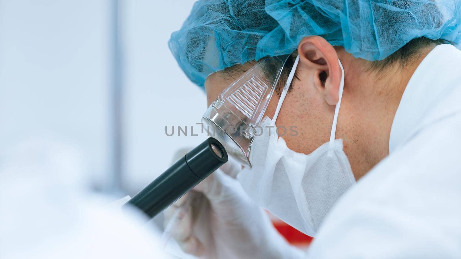 close up. serious scientist looking through a laboratory microscope. photo with copy-space.