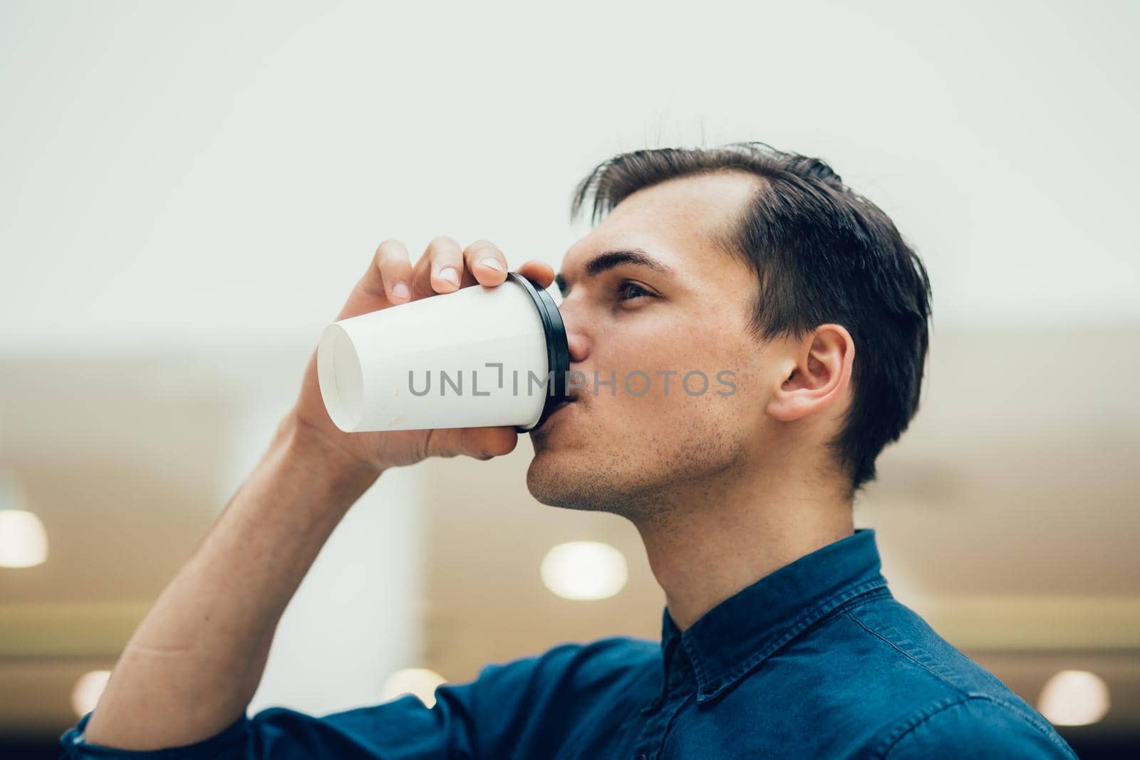 close up. an attractive young man with a coffee to take away