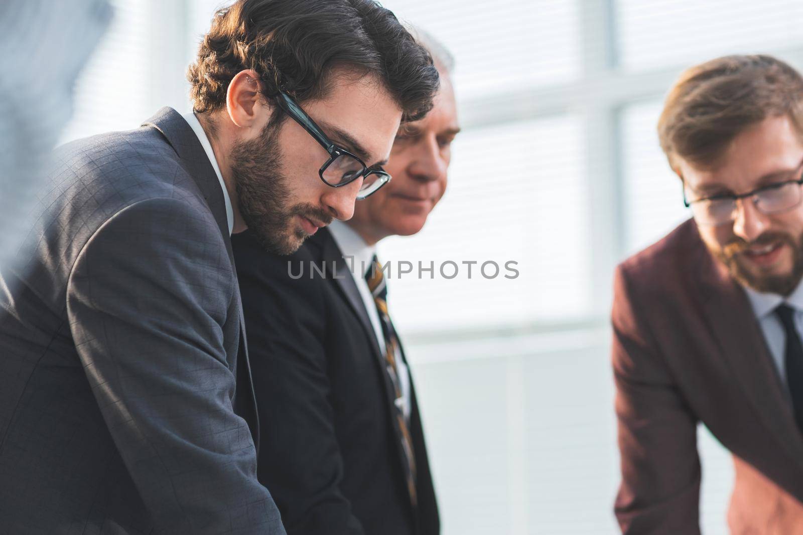 close up. serious business colleagues standing near the desktop. business concept