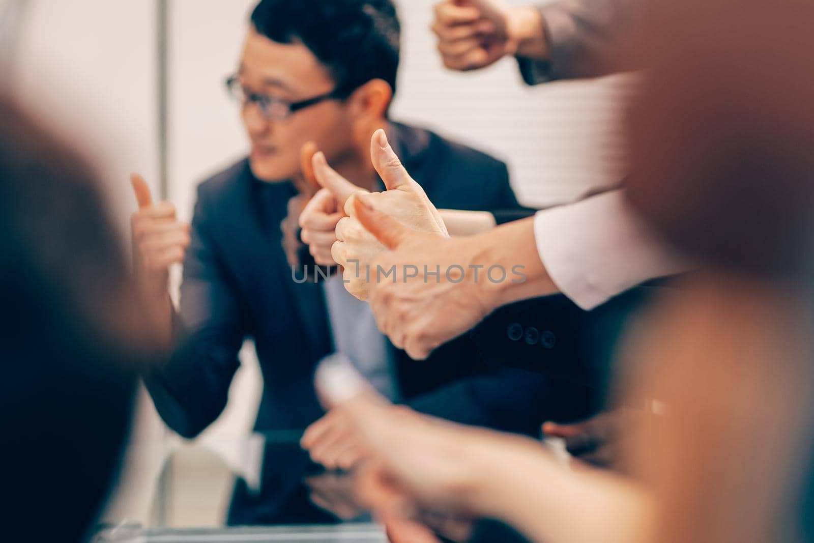 close up. group of young business people showing thumbs up. business background