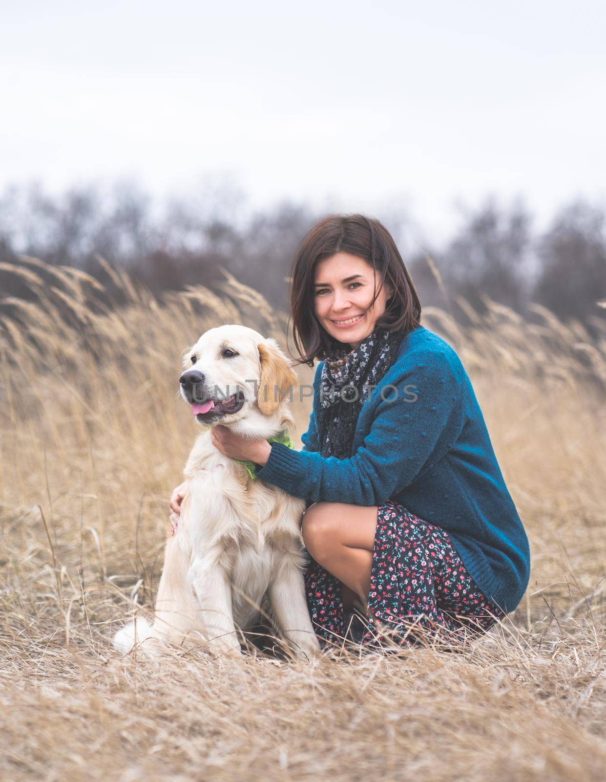 Happy woman next to cute young dog outside in early spring