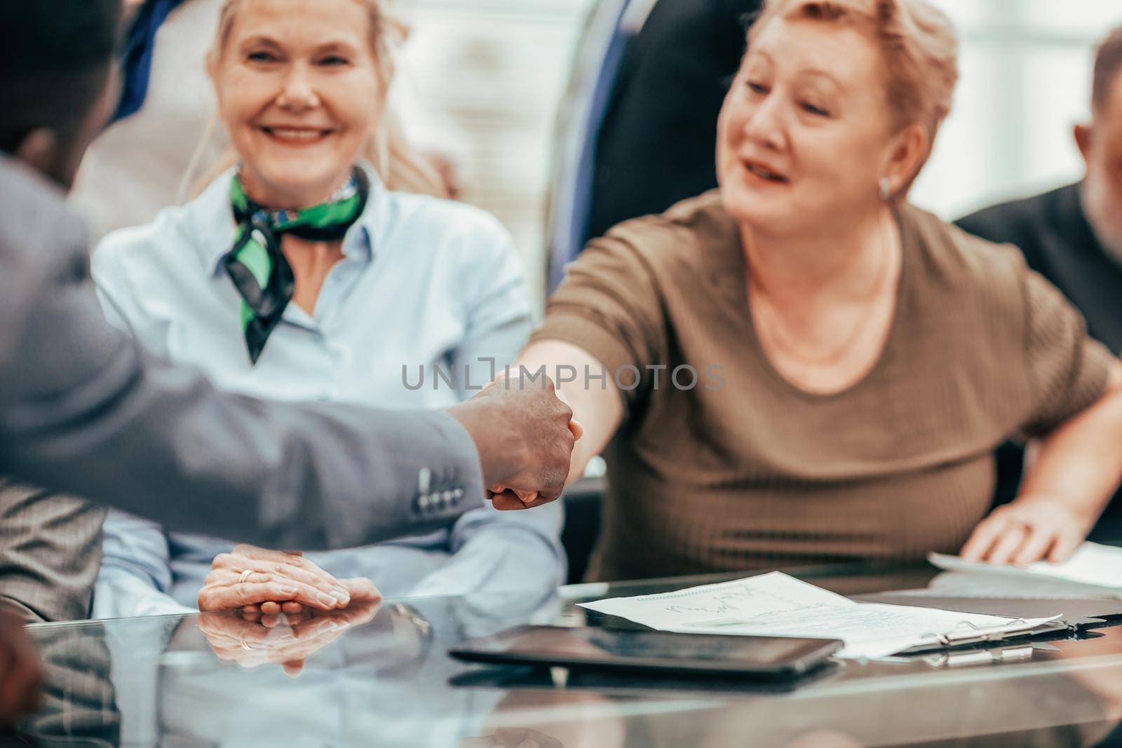 close up. senior businesswoman shaking hands with a young business partner. business concept