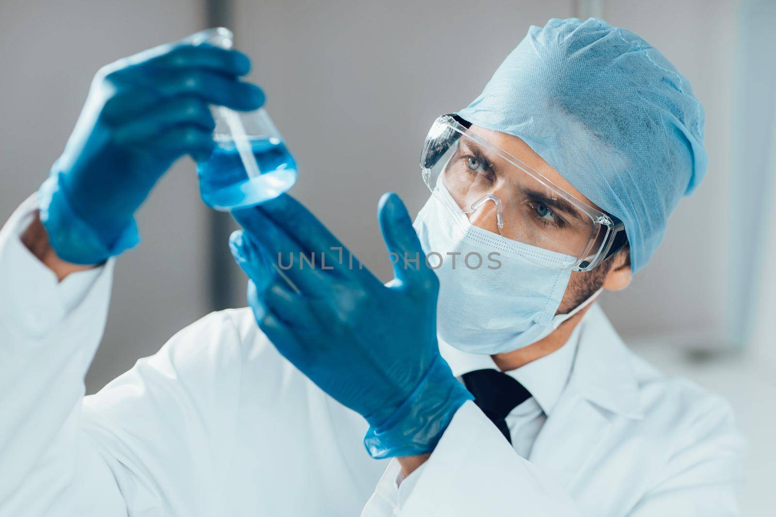 close up. researcher looking at a liquid in a medical flask. science and health.