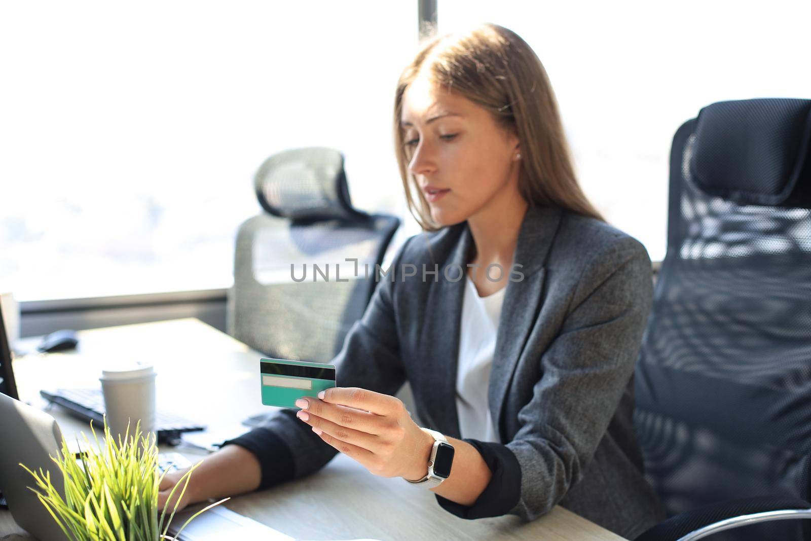 Woman holding credit card on laptop for online shopping concept