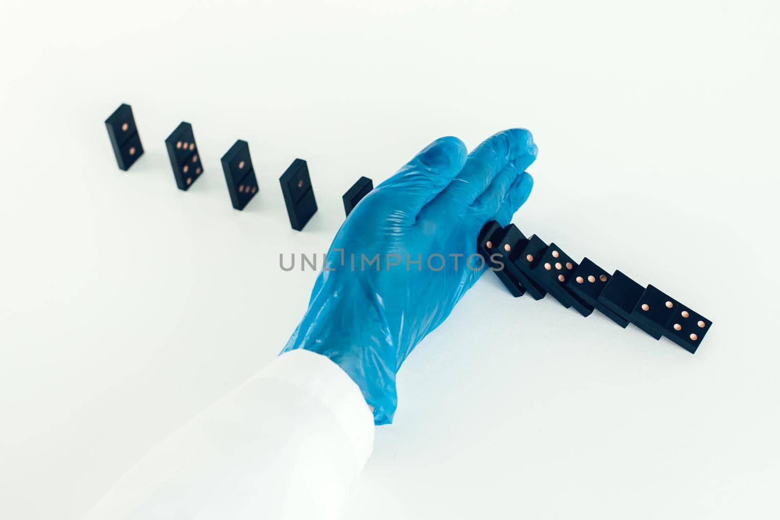 close up. doctor wearing protective gloves, placing dominoes . photo with a copy-space.