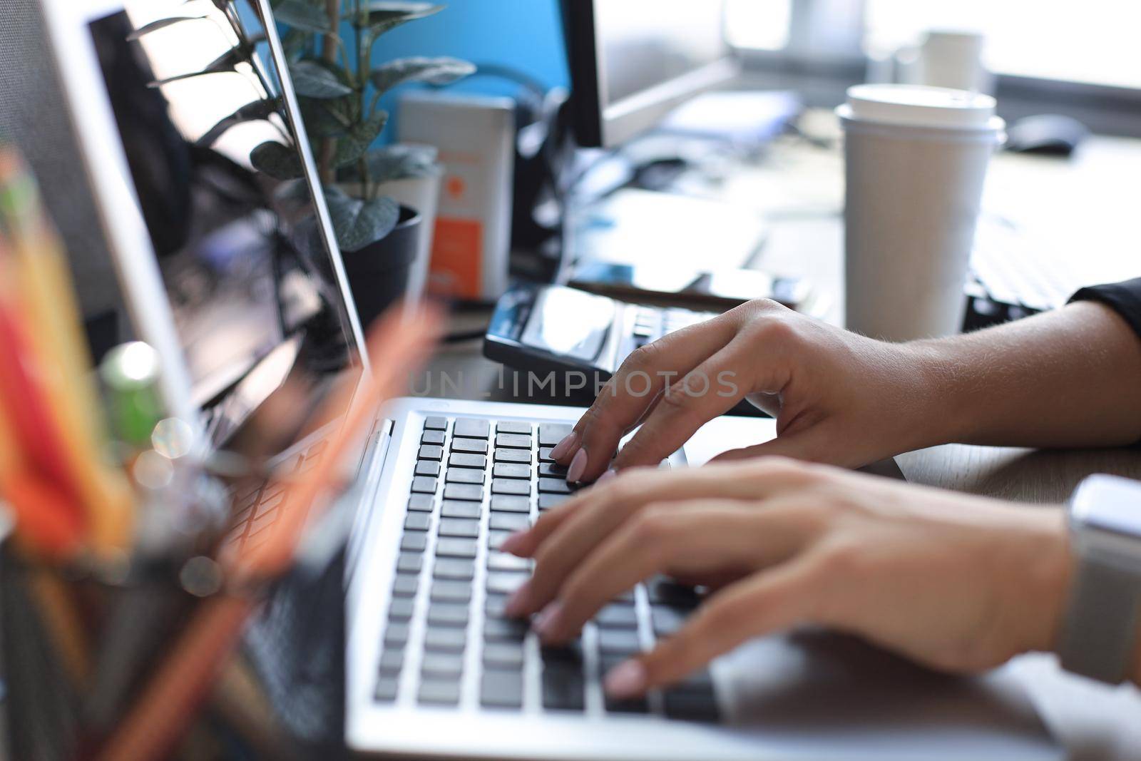 Close up of female hands busy typing on laptop in modern office. by tsyhun