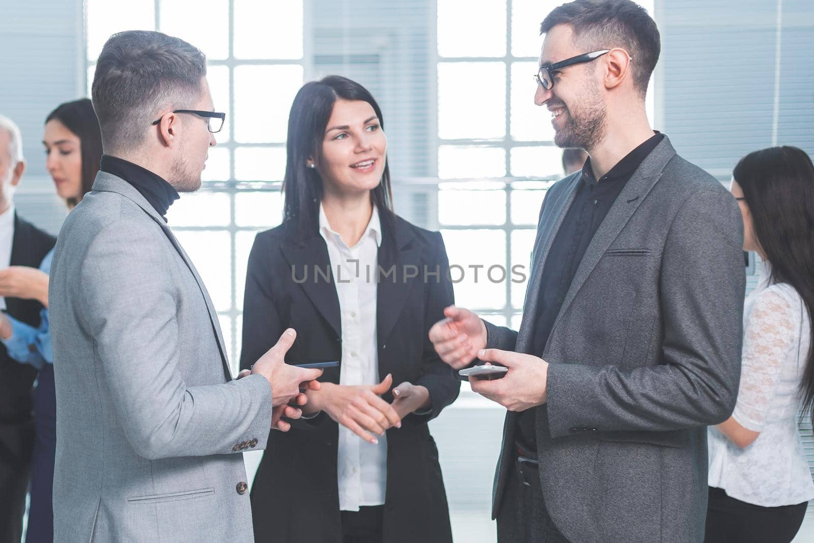 group of young employees standing in the office lobby during a work break. office workdays