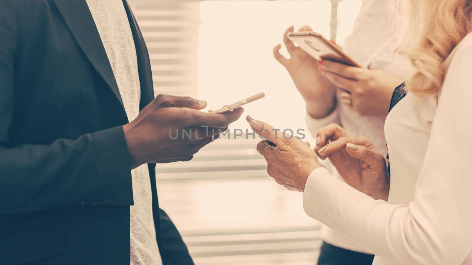 close up. young business people reading messages on their smartphones