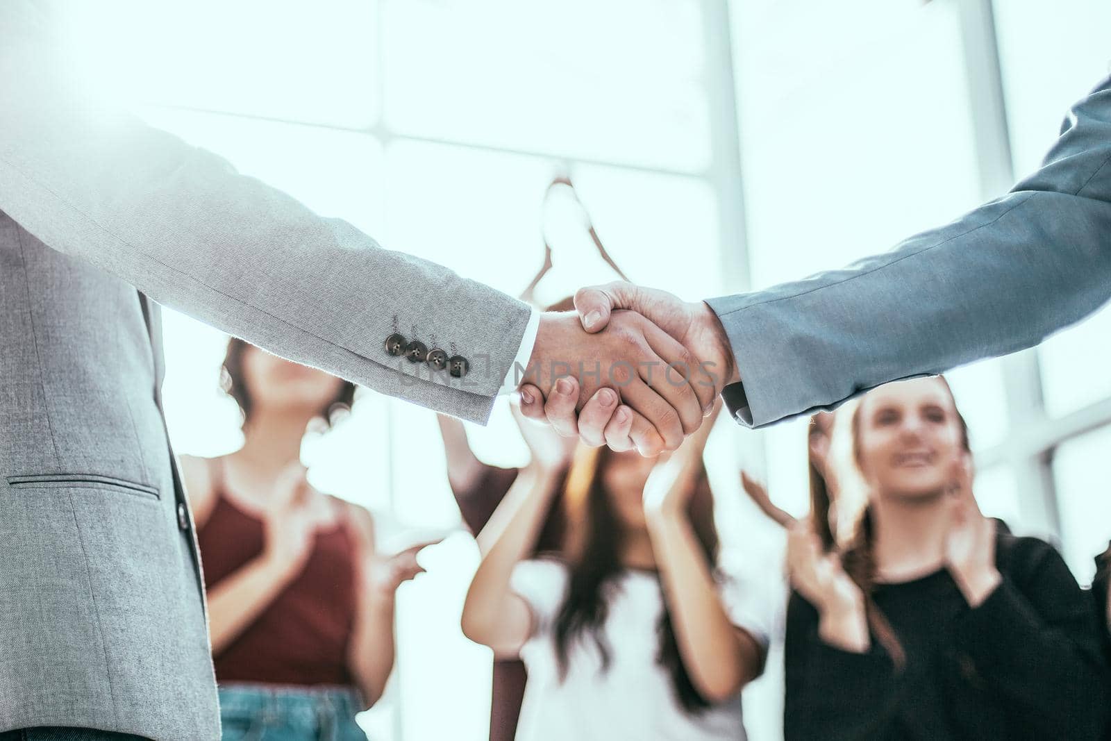 close up. confident young businessman shaking hands with business partner.