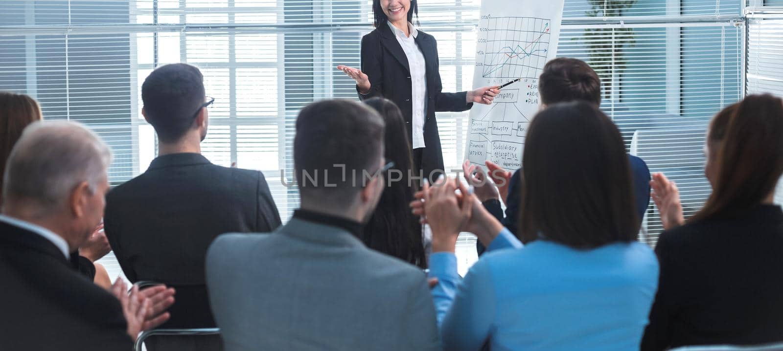 rear view. businesswoman making a presentation for the employees of the company