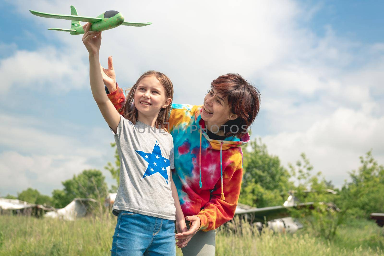 Mother and daughter playing with toy plane by GekaSkr