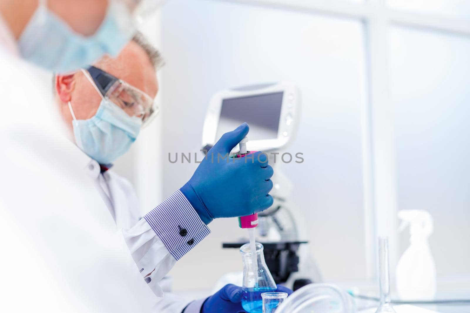 close up. employees of the scientific laboratory examining the liquid in a laboratory flask .