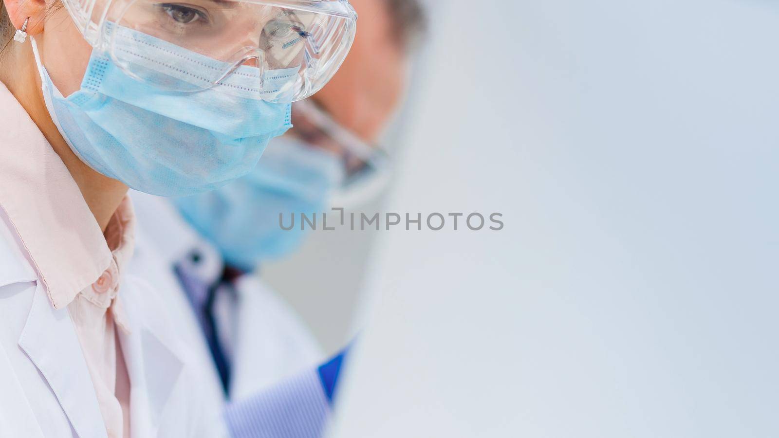 close up. serious woman scientist in a protective mask.