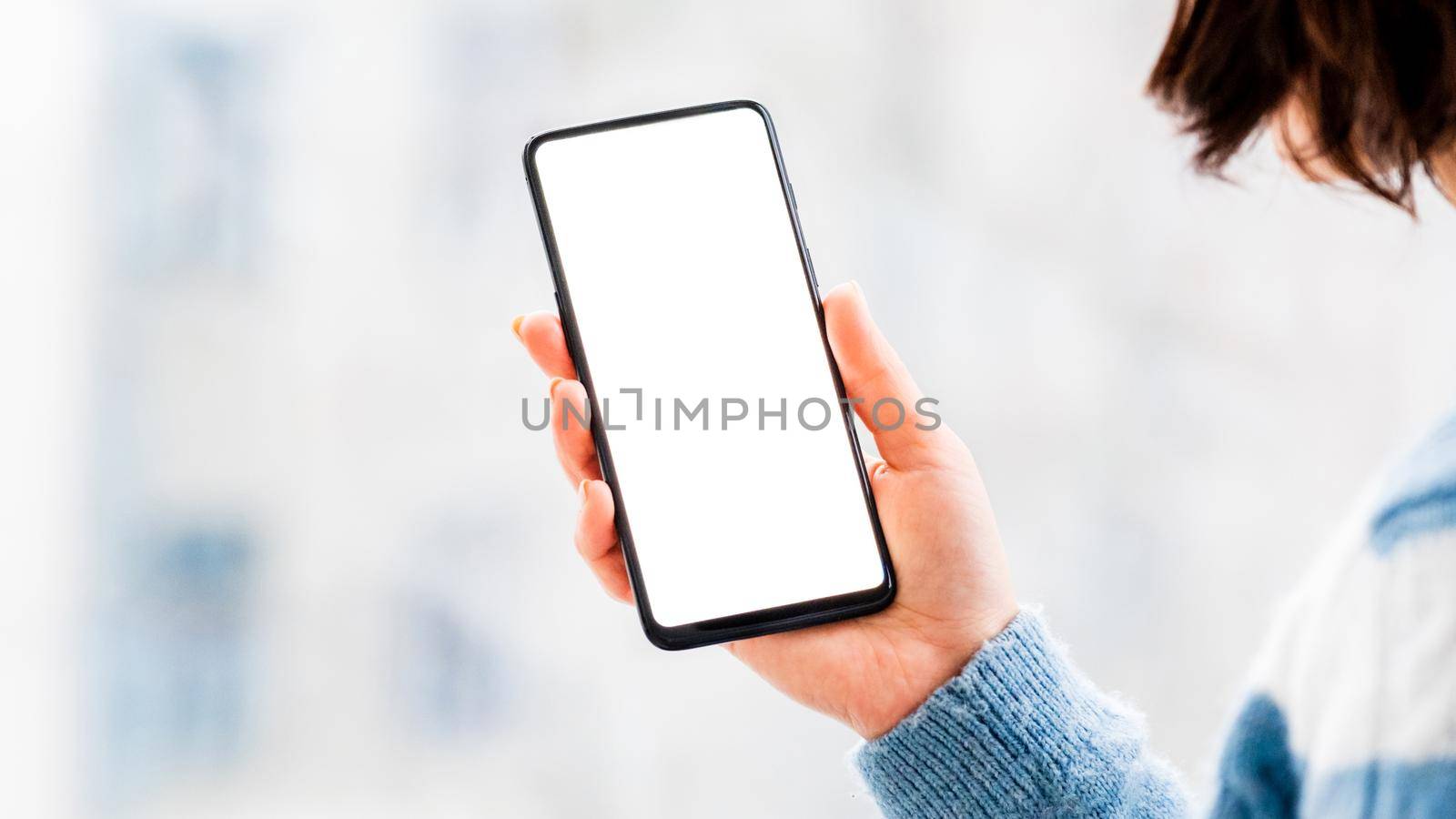 Hand holding mobile phone with white screen