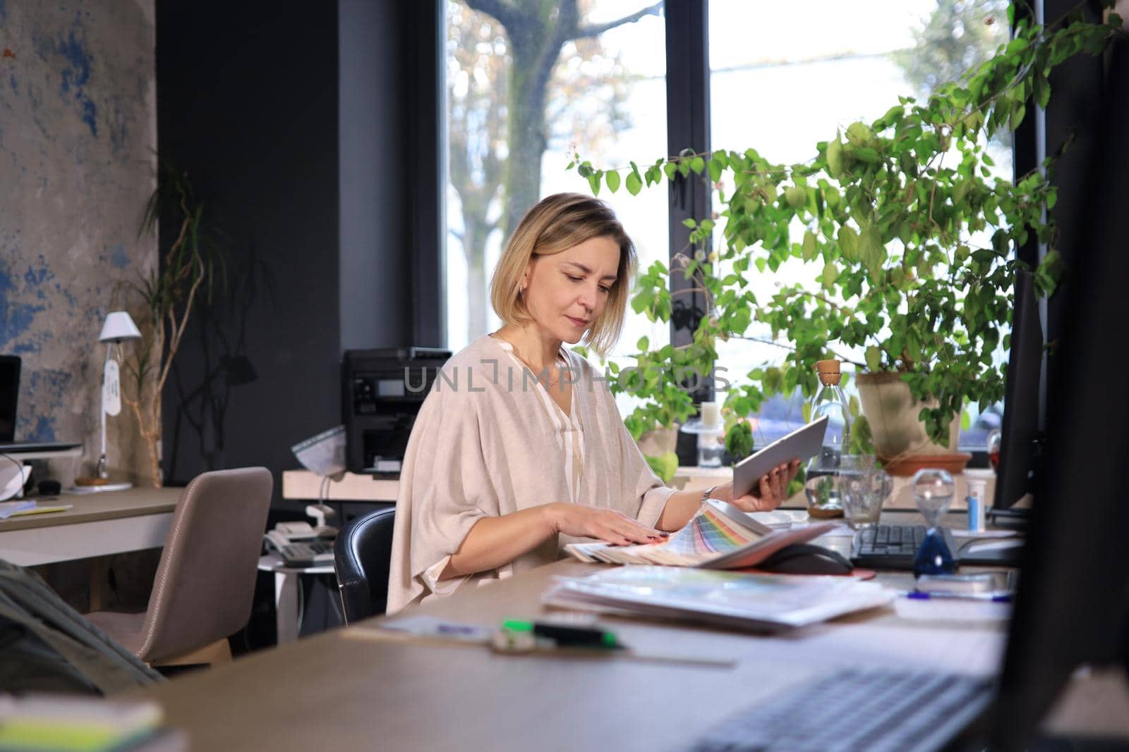 Beautiful business woman on the workplace using a digital tablet.