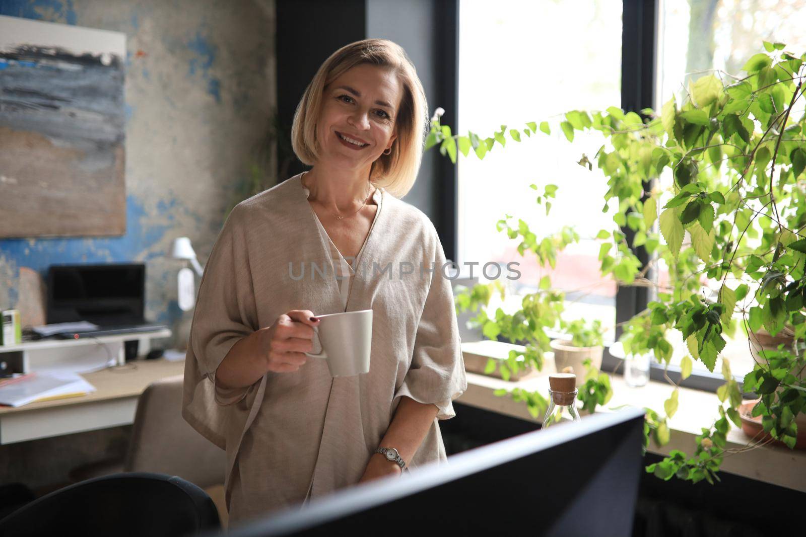 Attractive businesswoman standing near desk in the office.