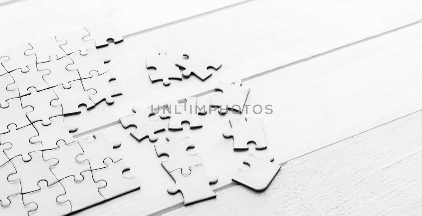 Pieces of empty jigsaw puzzle on white table
