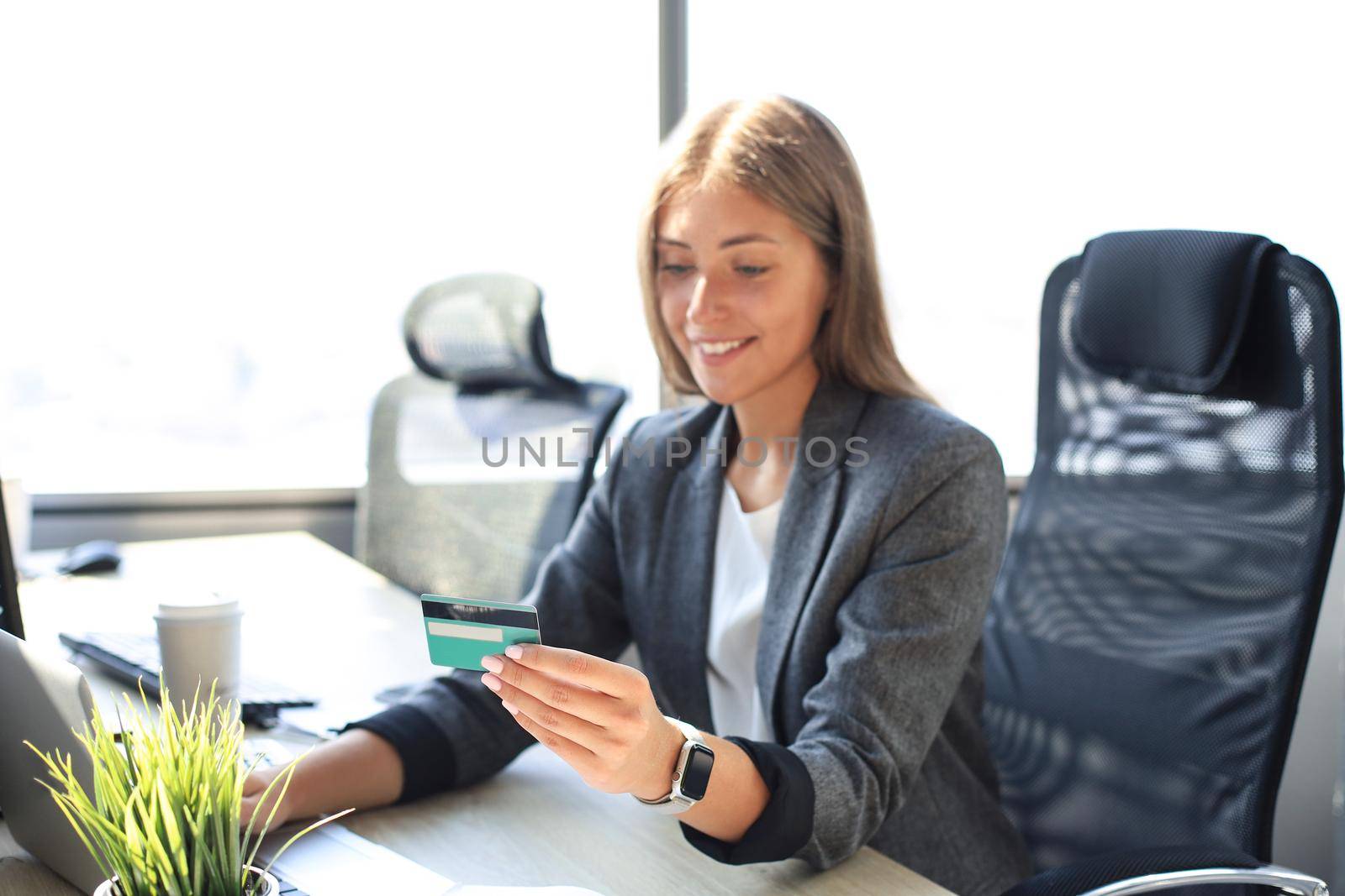 Woman holding credit card on laptop for online shopping concept