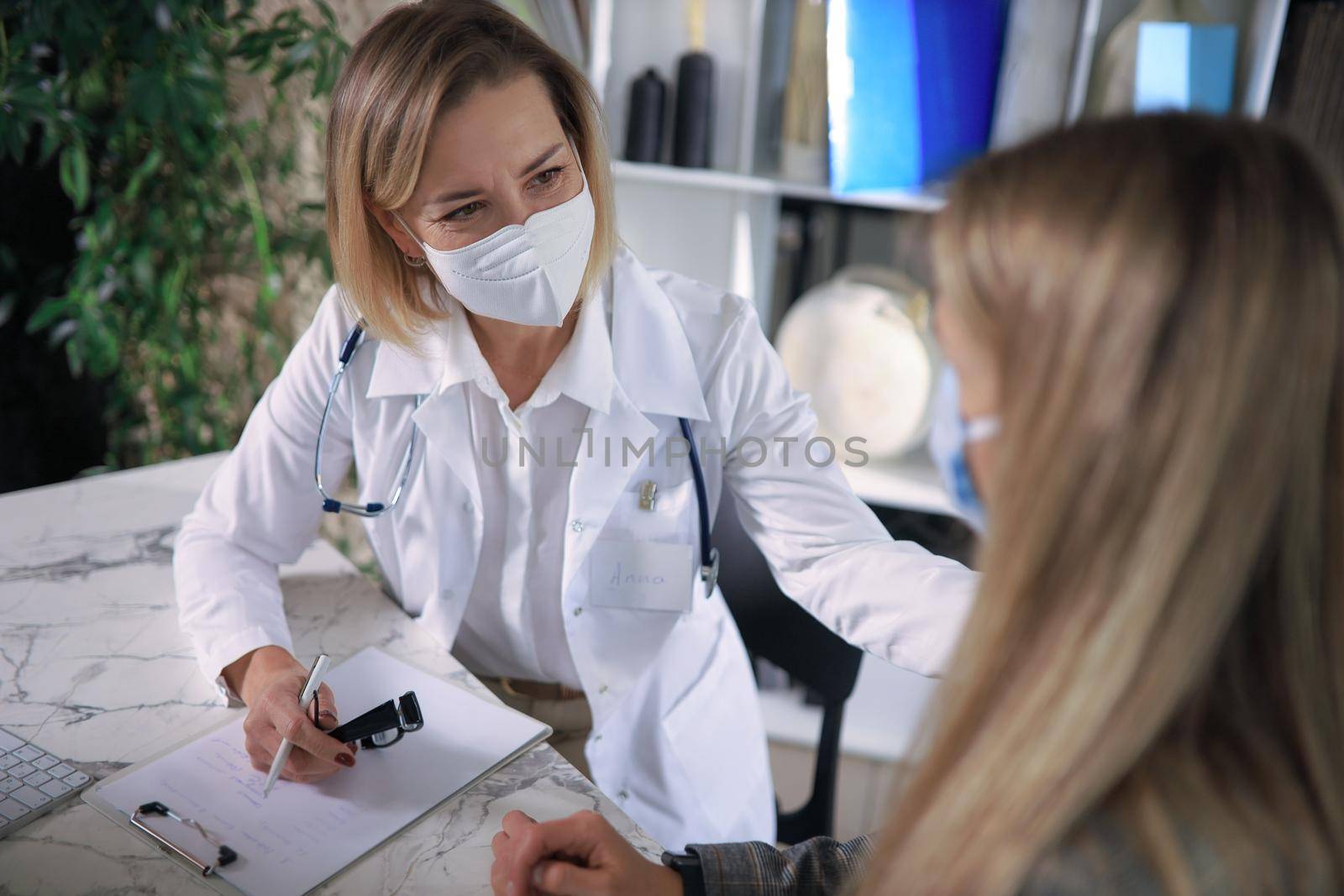 Friendly middle aged female doctor encouraging, supporting patient after medical examination