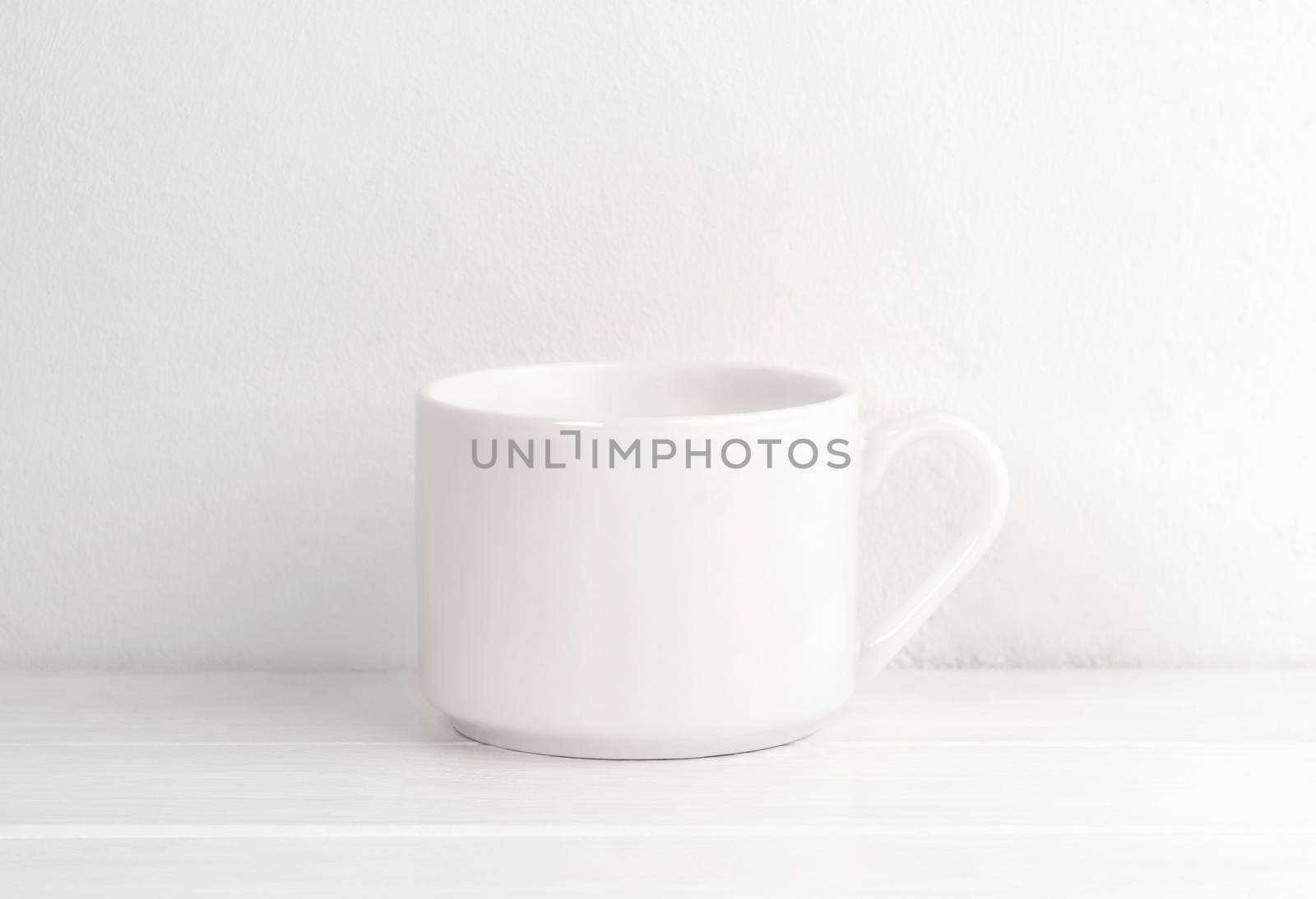 Ceramic cup on white table for your design