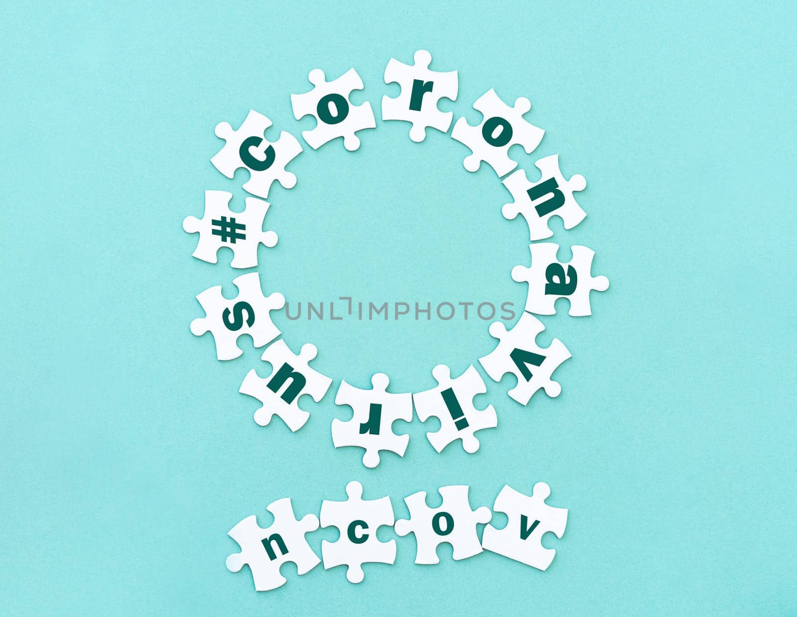 Circle made of white jigsaw puzzle pieces with word coronavirus on blue, top view