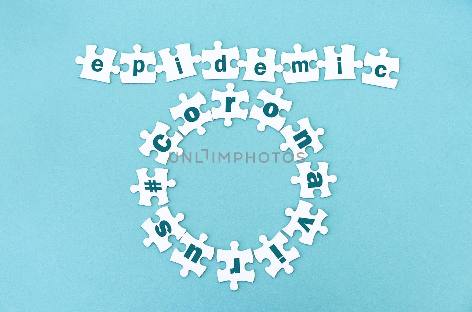 Circle and row made of white jigsaw puzzle pieces with word epidemic andcoronavirus on blue