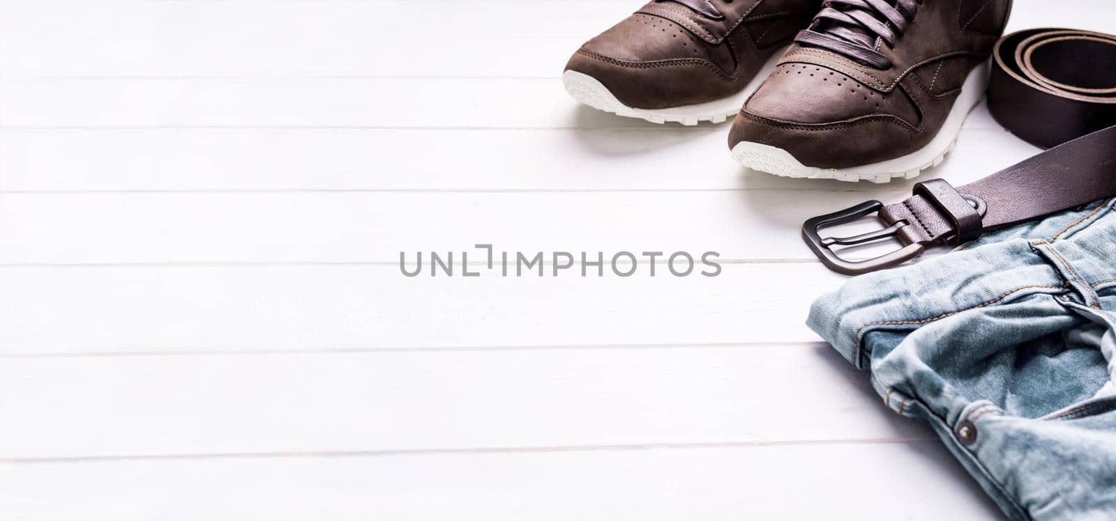 male jeans, belt and shoes on wooden background with text space, with copyspace