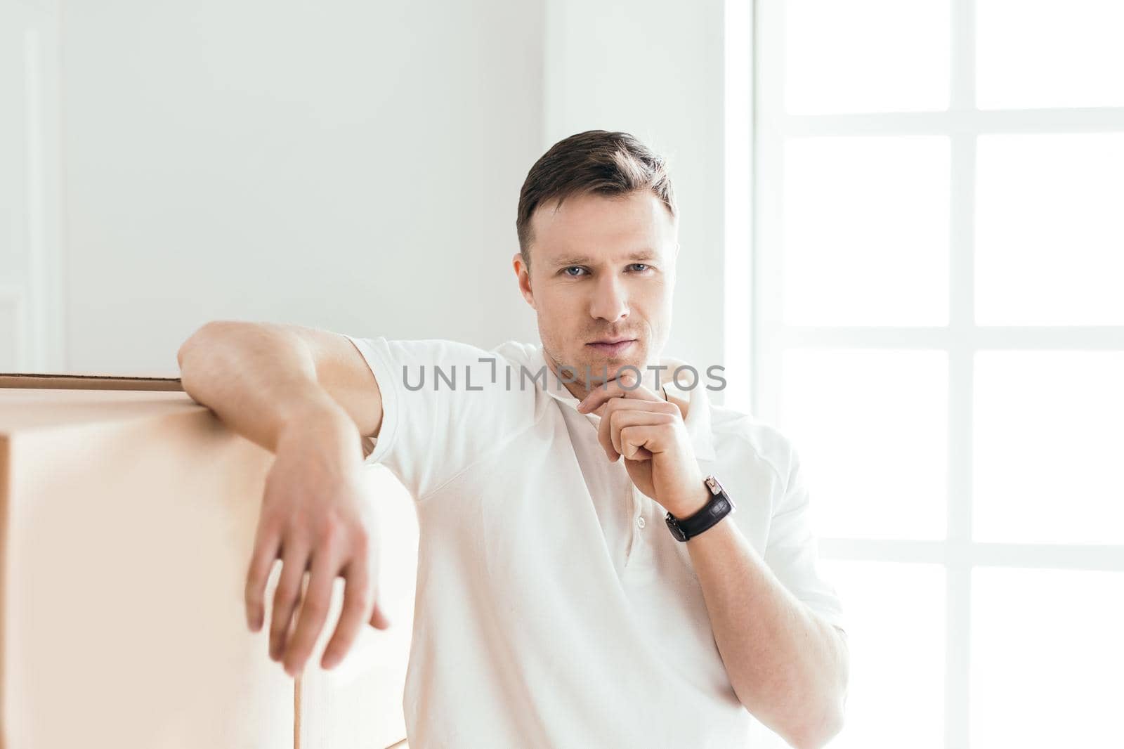 close up. pensive young man standing near cardboard boxes