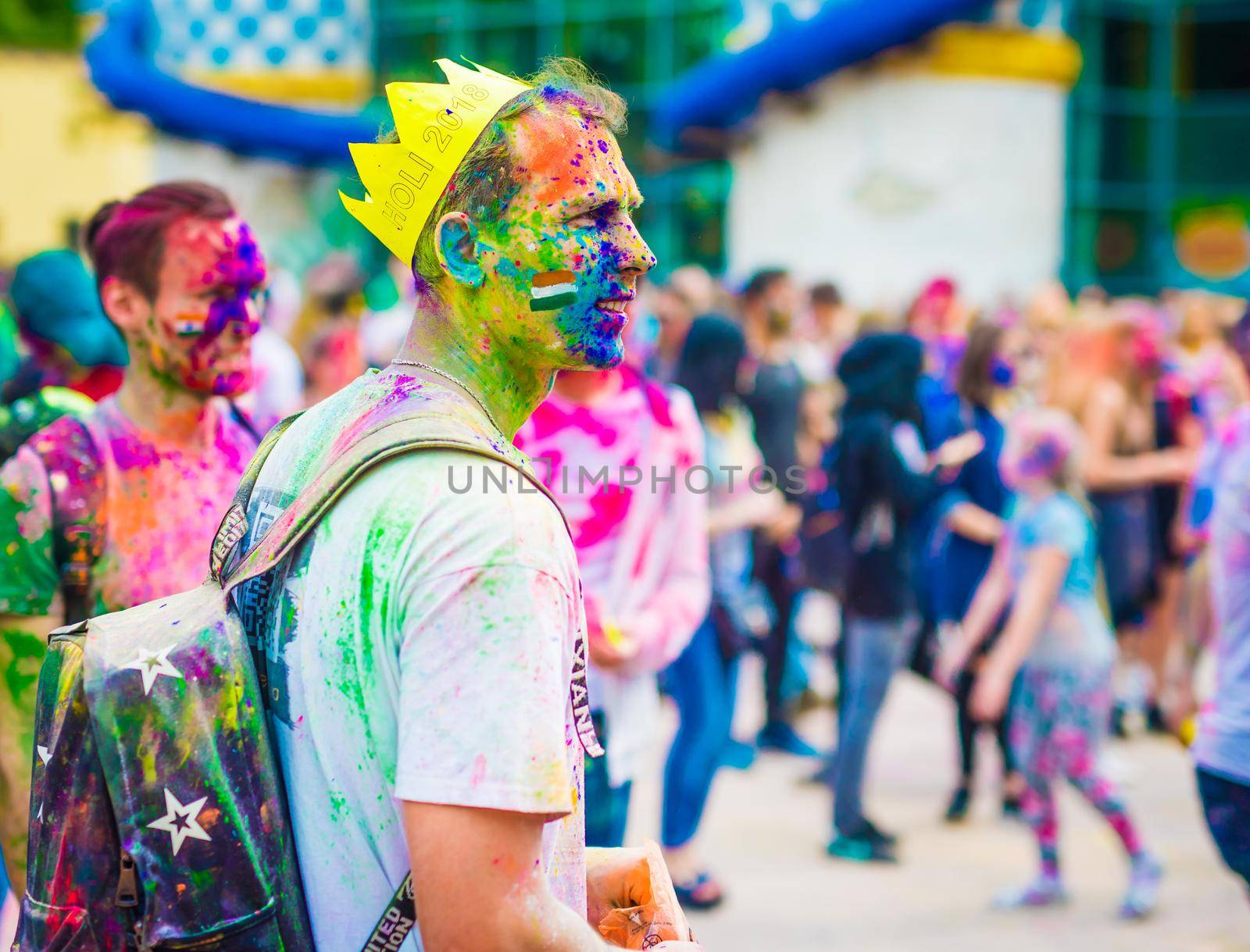 Khakiv, Ukraine - 19 May 2018: People sprinkle colorful paints during the festival. People with colorful faces celebrating holi fest