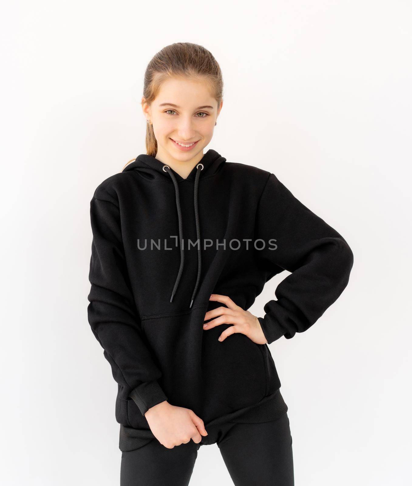 Attractive teenage girl posing in black hoodie isolated on white background