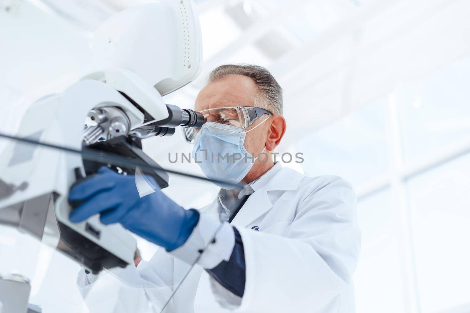 close up. serious scientist using a laboratory microscope. science and health protection.