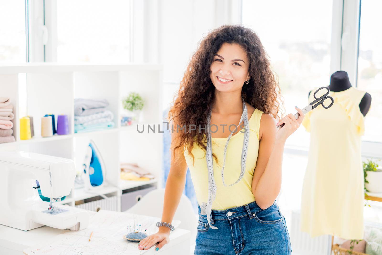 Young cute designer with finished dress on mannequin