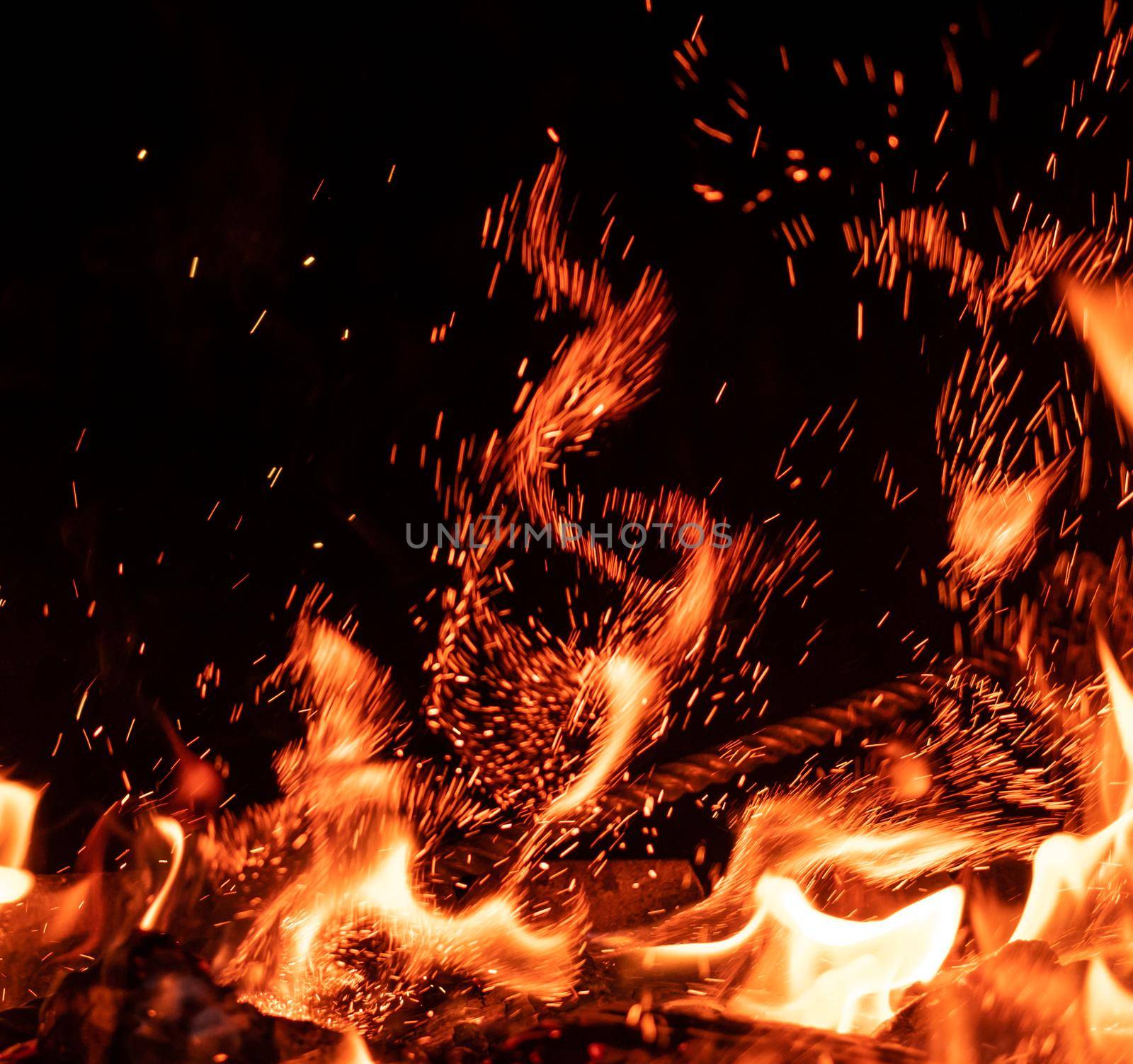 Beautiful fire flame with sparks isolated on black background. Night view of bonfire