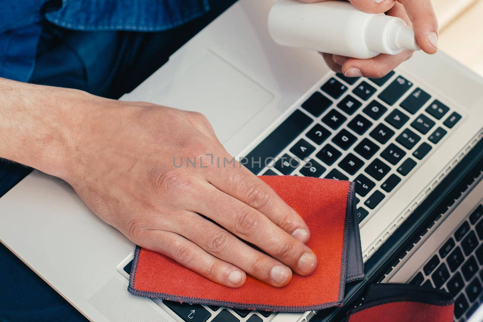 close up. young man decontaminating his laptop . concept of health protection