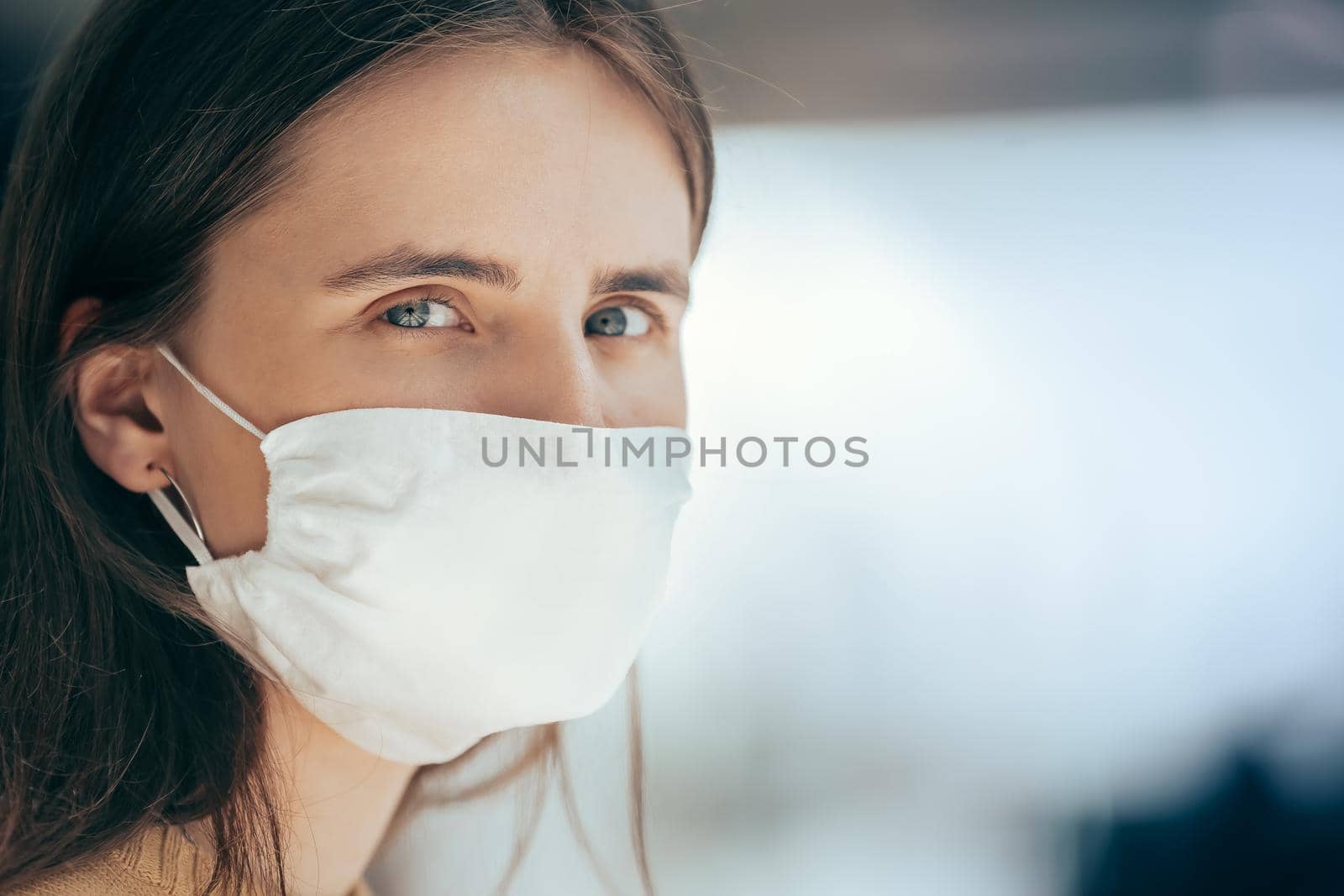 close up. a young woman in a protective mask looking at you