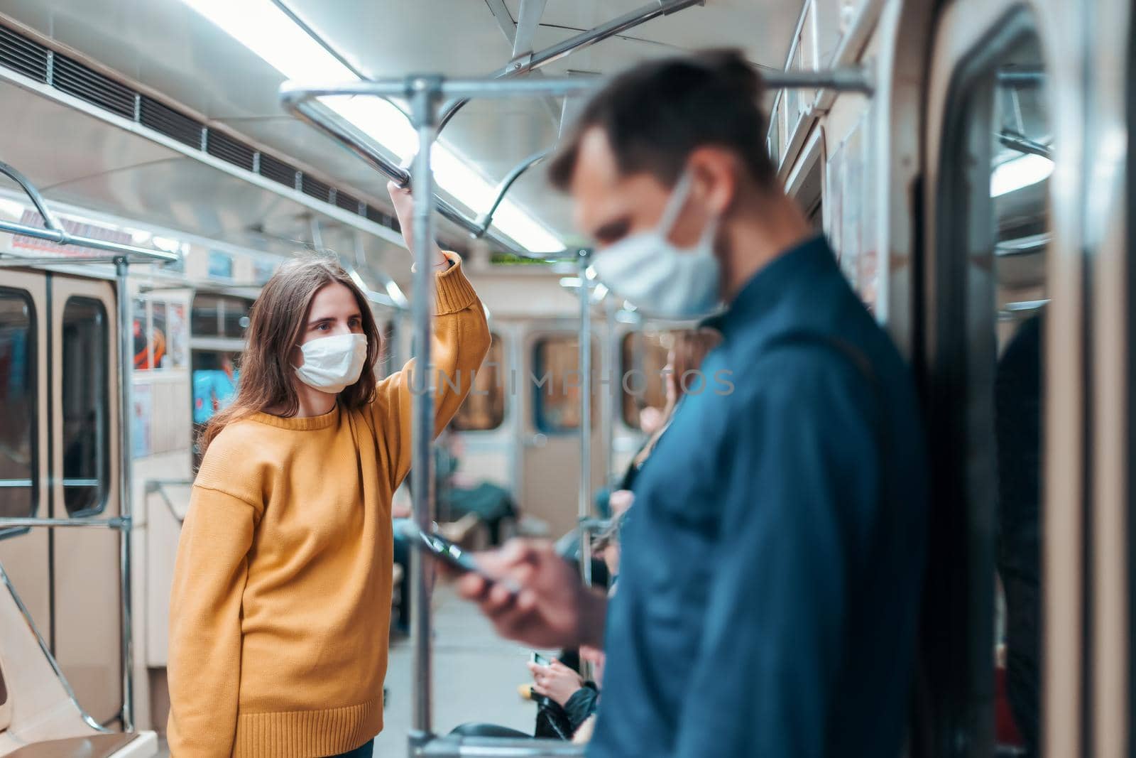 young woman in a protective mask standing in a subway car. coronavirus in the city