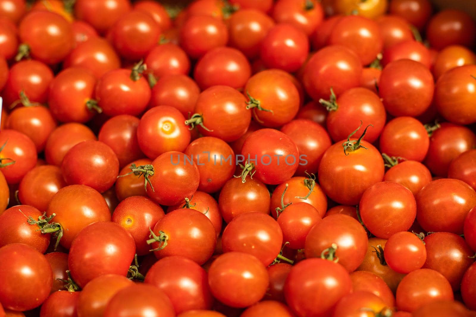 Stock photo of tasty fresh cherry tomatoes are being sold at the market. Close-up of raw cherry tomatoes.