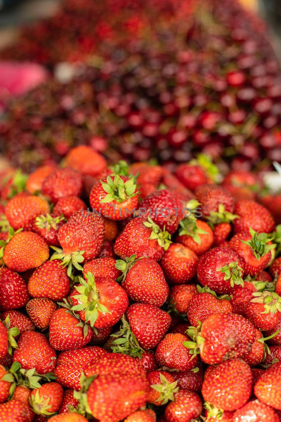 Picture of sweet, tasty and fresh strawberries lying in wooden boxes in the store by StudioLucky