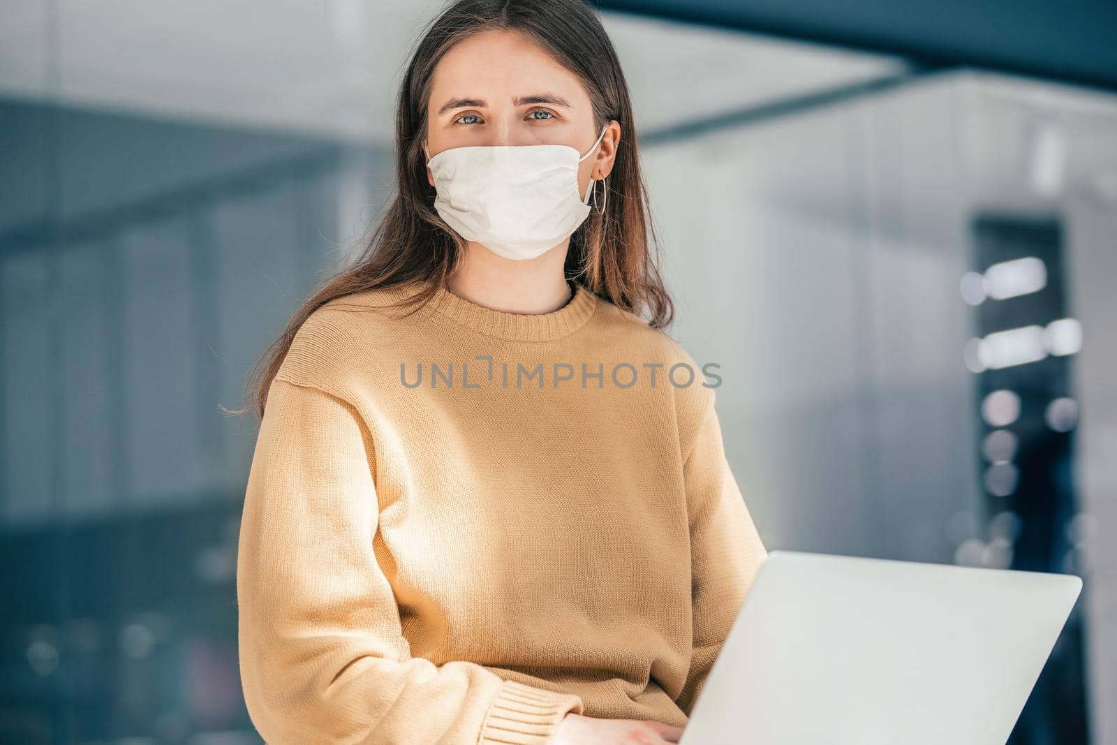 young woman with a laptop sitting on a city street. people and technology