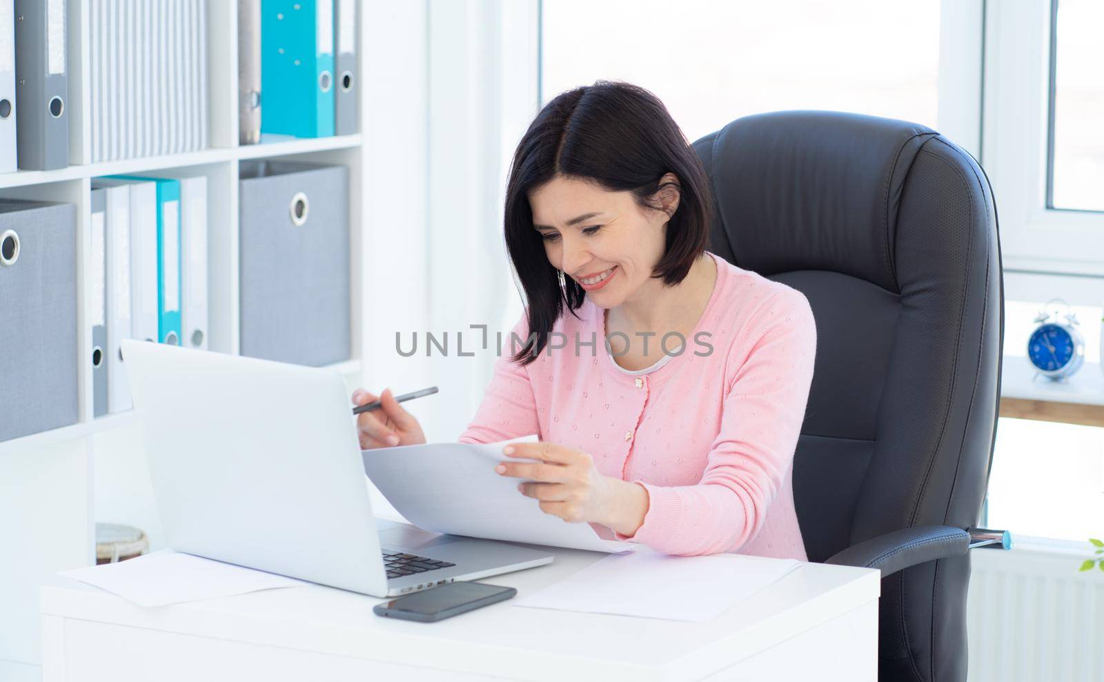 Beautiful woman working with papers in light room