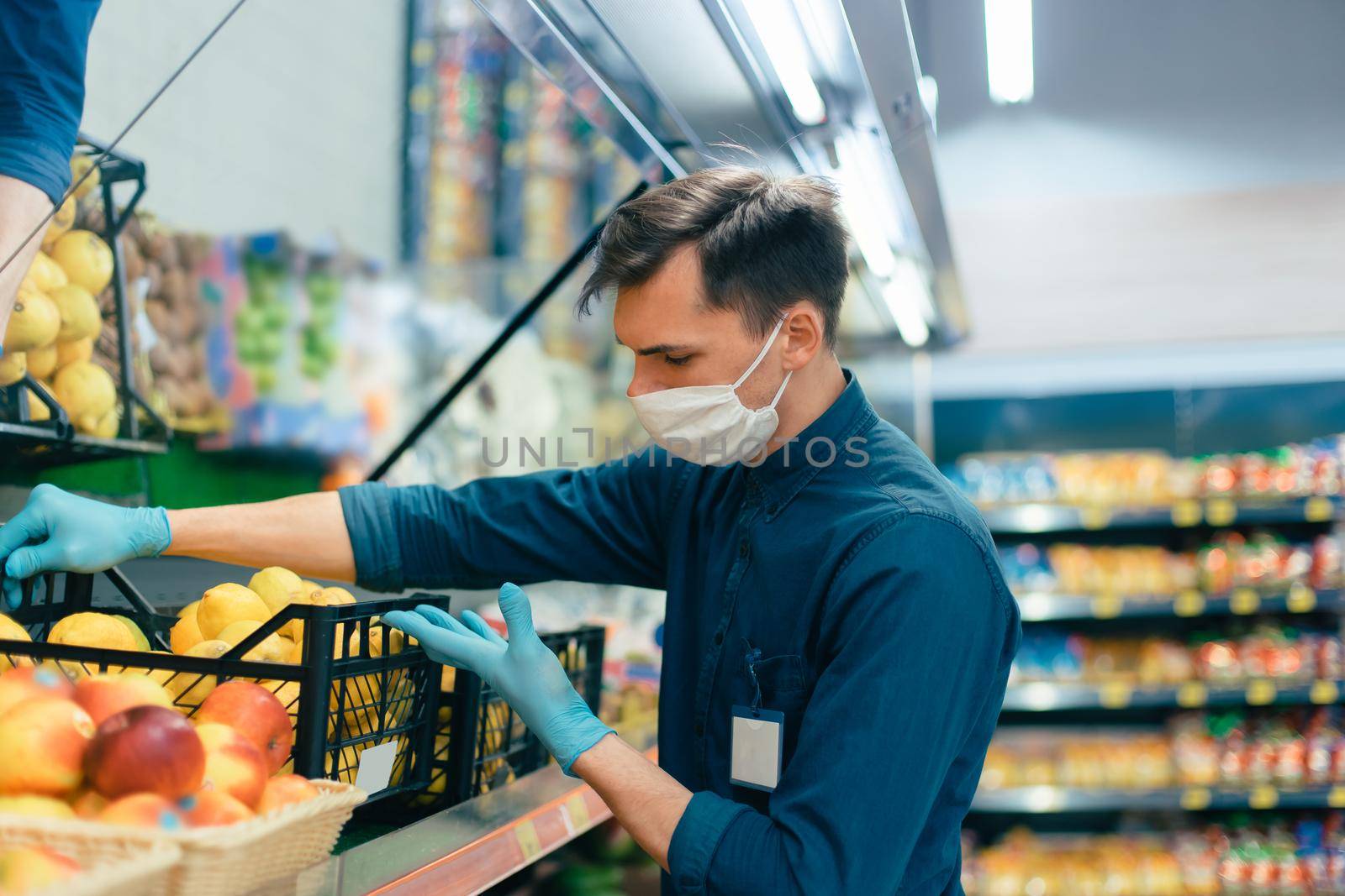 seller in a protective mask standing in front of the counter with fruit. coronavirus in the city