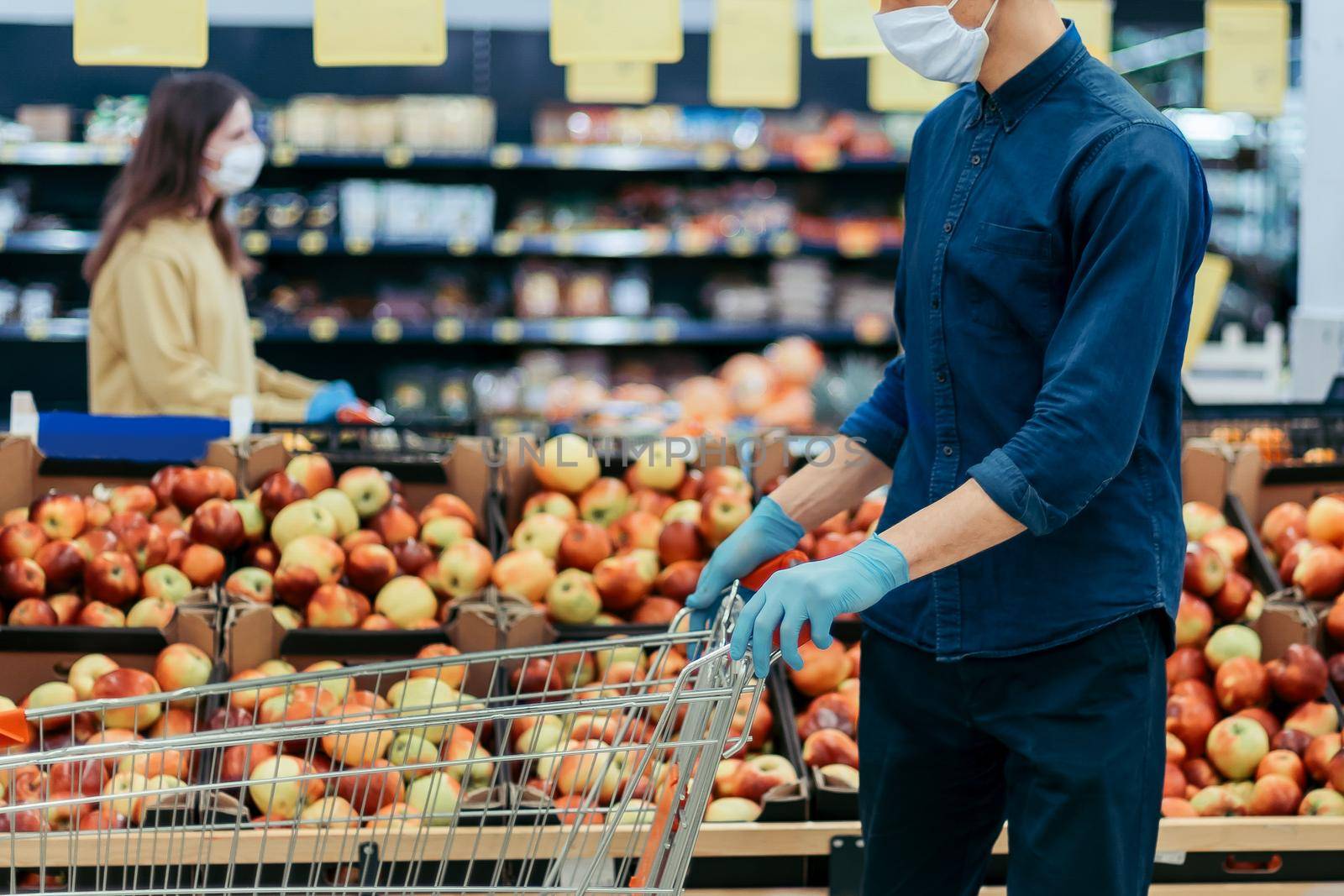 shoppers in protective masks standing in a supermarket at a safe distance. photo with a copy of the space