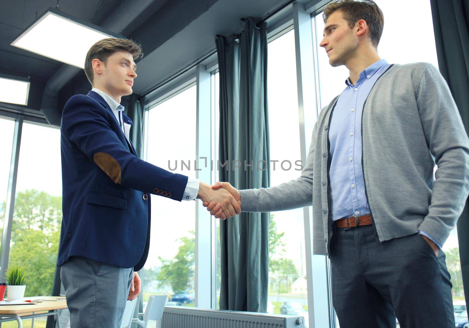 Two businessman shaking hands. Welcome to business. by tsyhun
