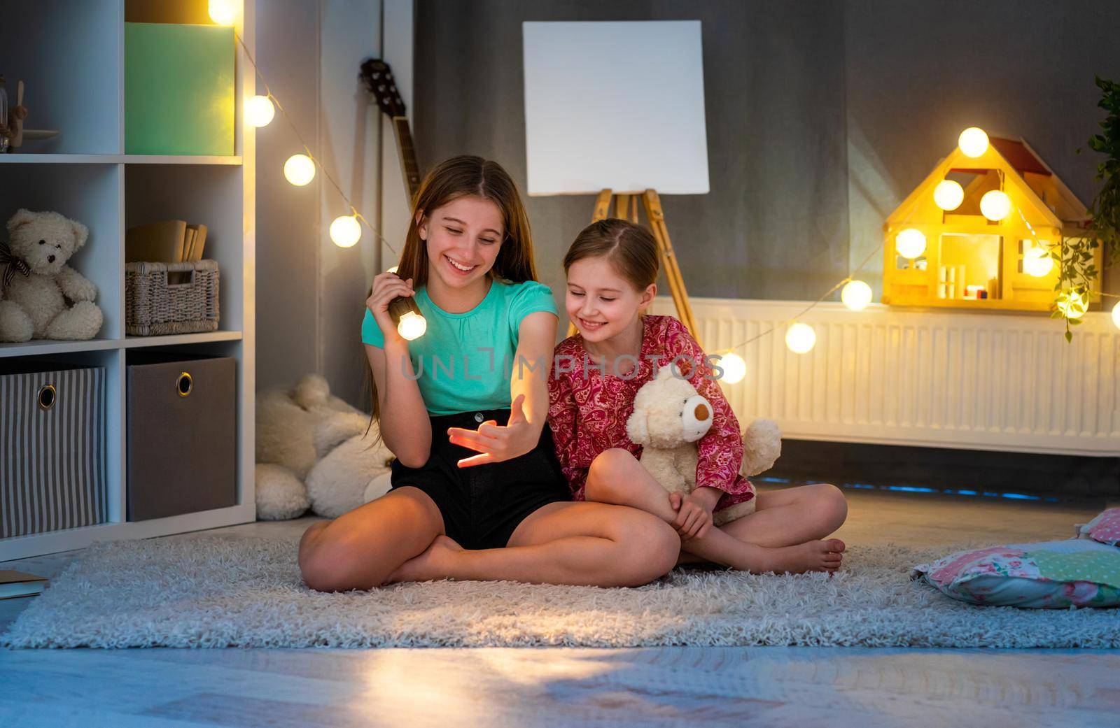 Smiling girls making hand shadow theatre by GekaSkr