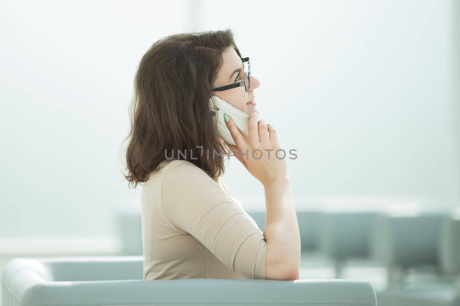 businesswoman talking on a smartphone sitting in the office room .photo with copy space