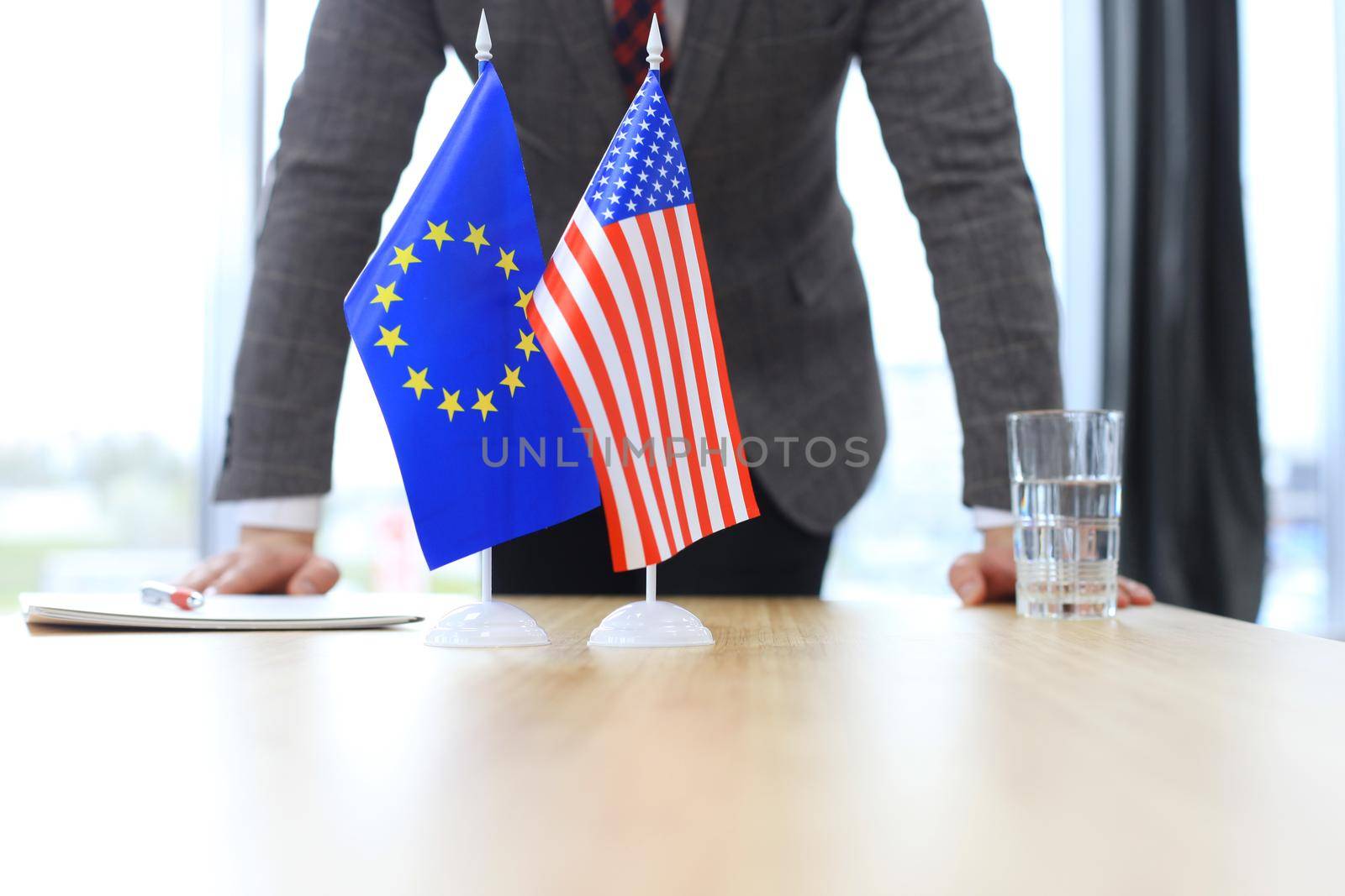 Chinese flag and flag of European Union with businessman near by by tsyhun