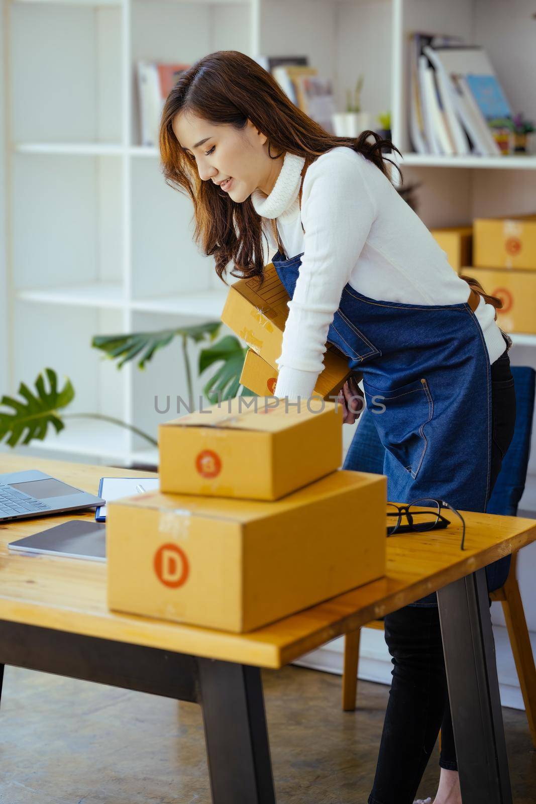 Work from home. happy women selling products online Startup small business owners are picking up parcel boxes to pack customer orders and prepare them for postage