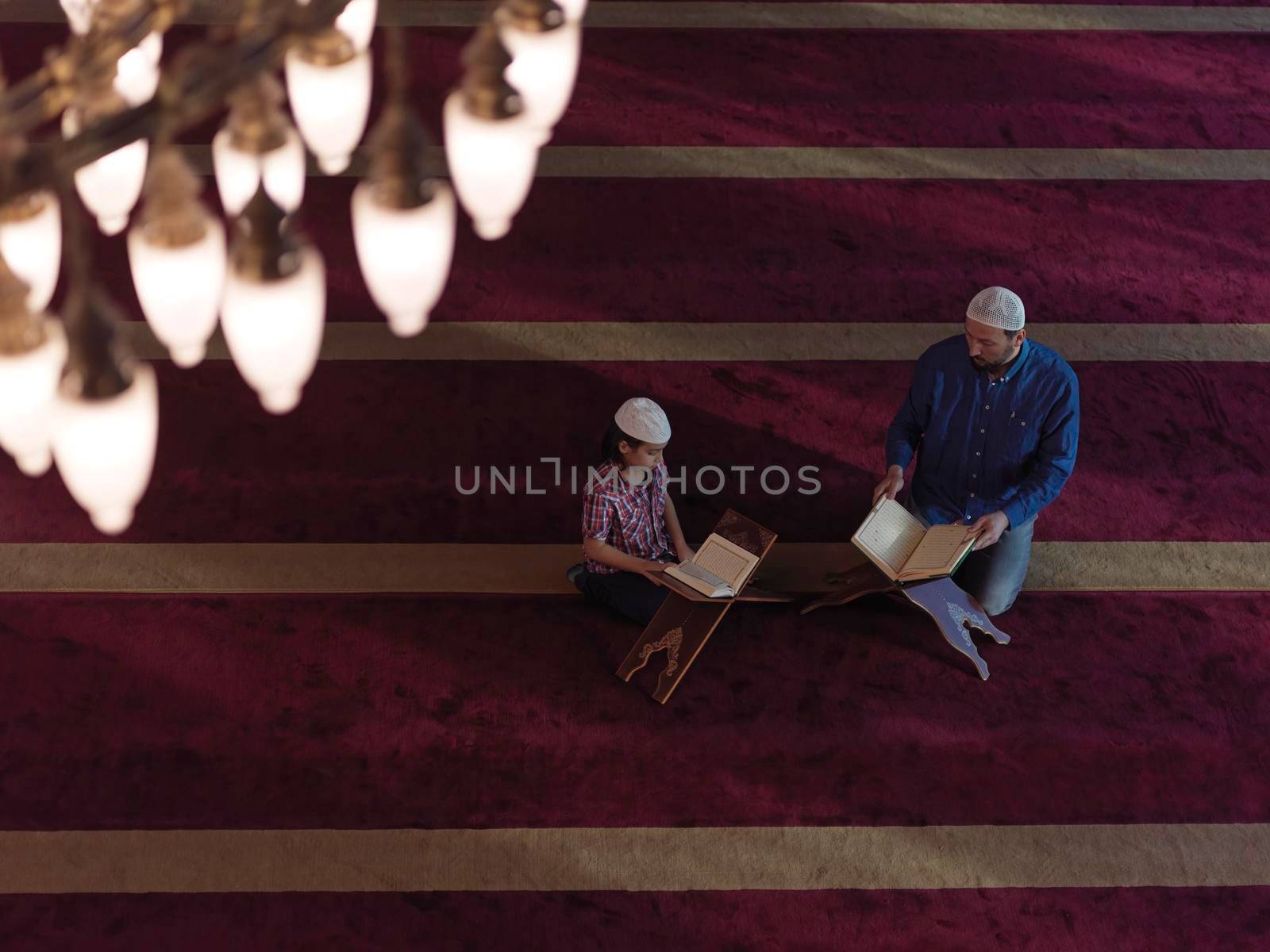 muslim prayer father and son in mosque praying and reading holly book quran together islamic education concept