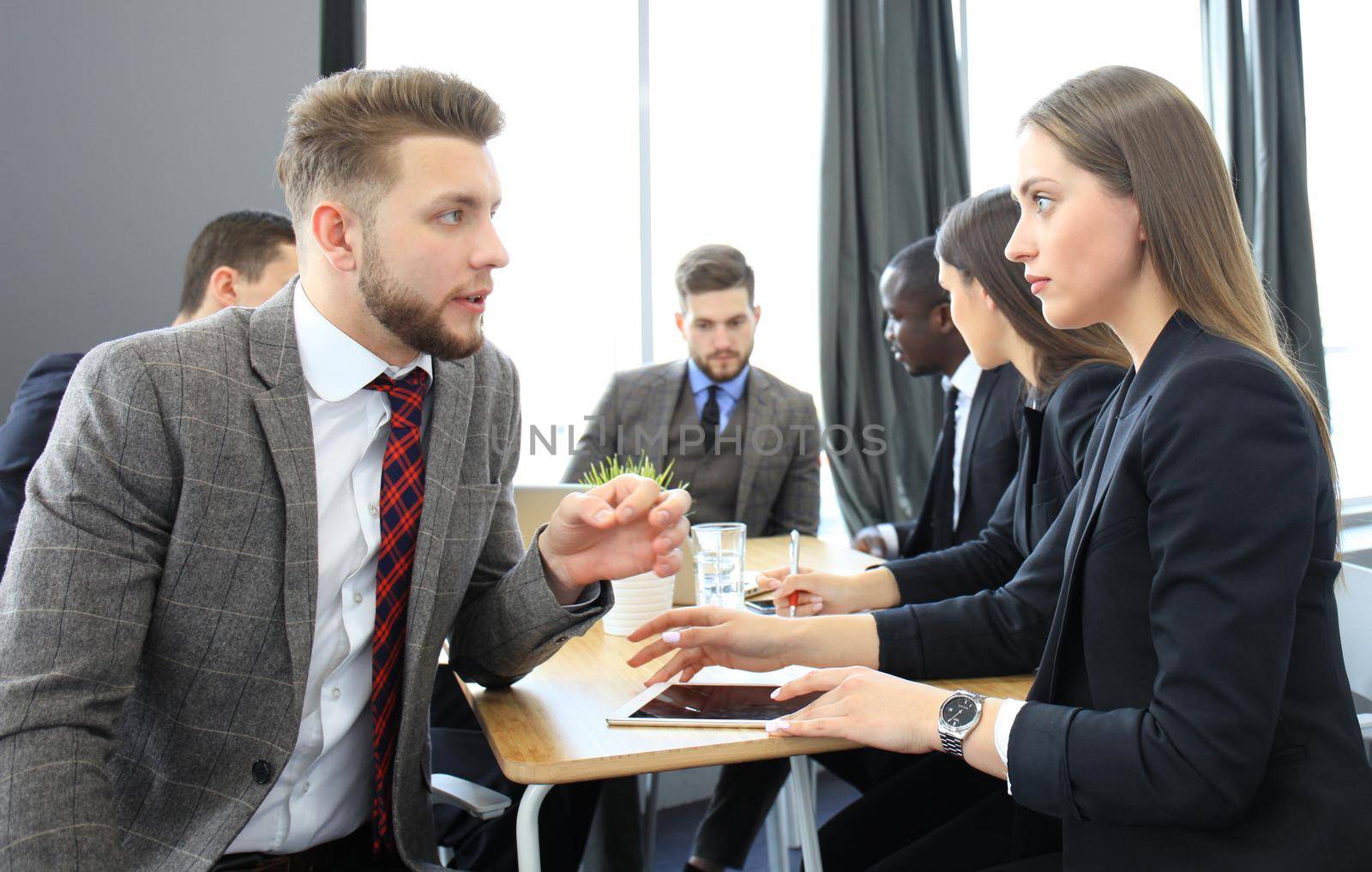 Image of two young business people interacting at meeting in office