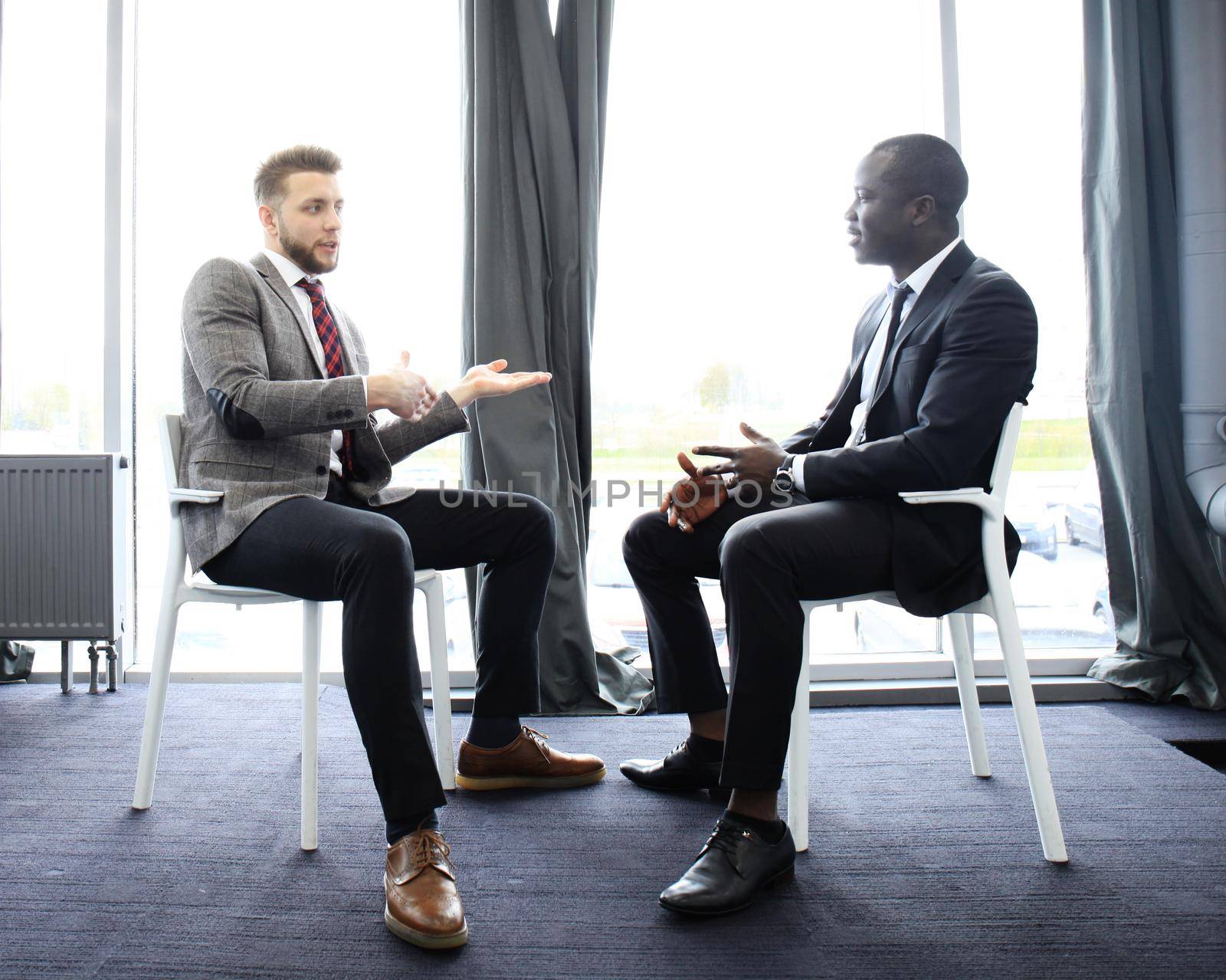 Two business colleagues at meeting in modern office interior by tsyhun